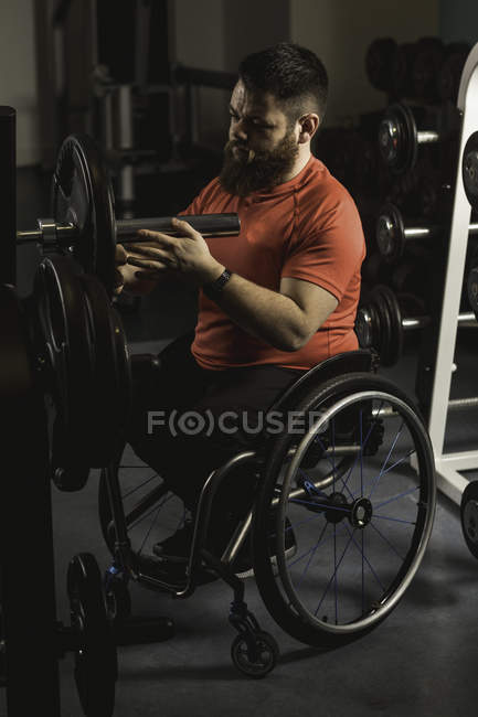 Deficiente homem ajustando barbell no ginásio — Fotografia de Stock