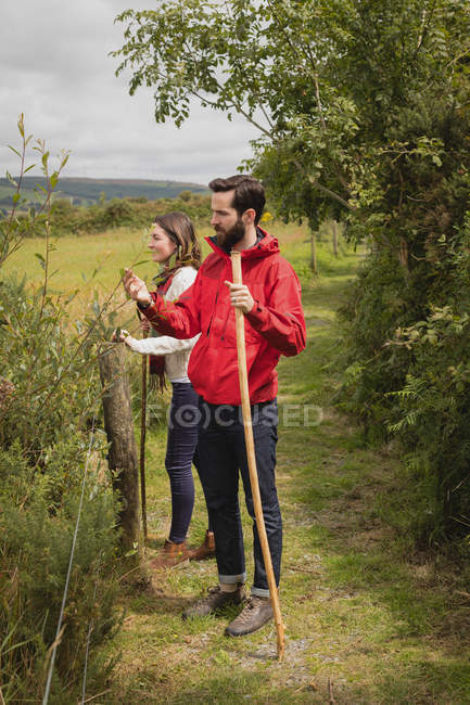Casal em pé no caminho perto do campo — Fotografia de Stock