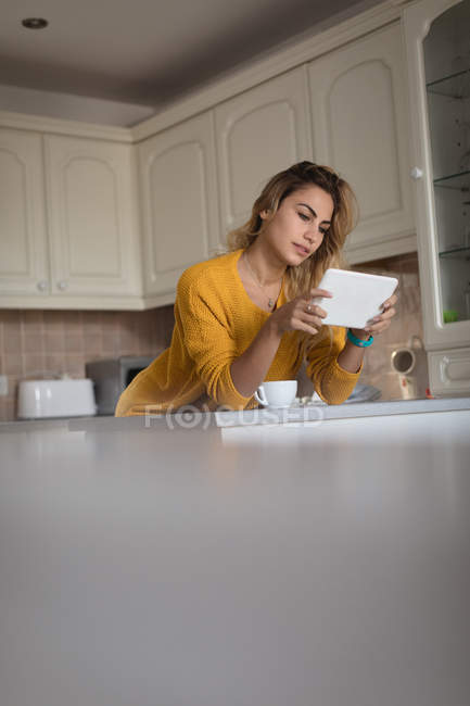 Frau nutzt digitales Tablet zu Hause in der Küche — Stockfoto