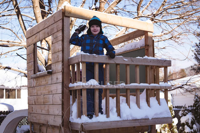 Porträt eines niedlichen Jungen, der im Winter auf einem Spielplatz mit Schnee spielt — Stockfoto
