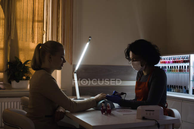 Kosmetikerin behandelt Kundin im Salon mit Maniküre — Stockfoto