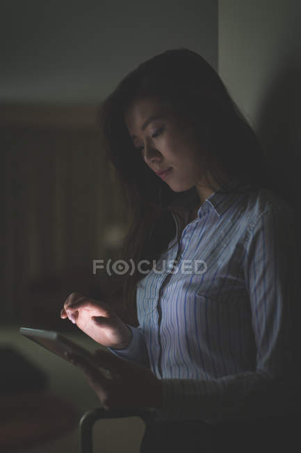 Donna d'affari che utilizza tablet digitale in camera d'albergo — Foto stock