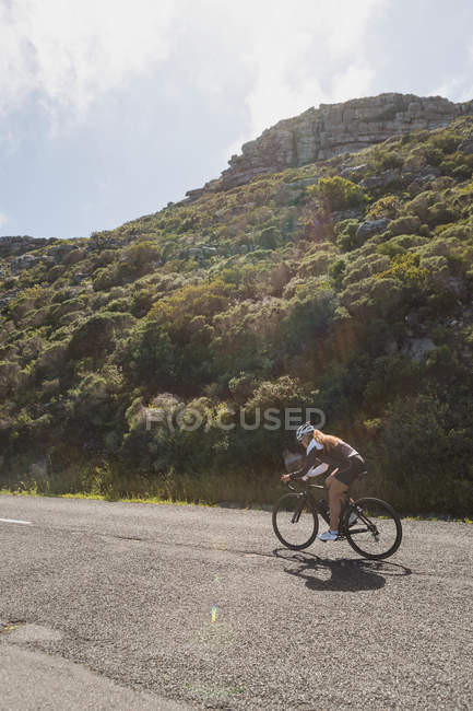 Pedalare in mountain bike su strada in una giornata di sole — Foto stock