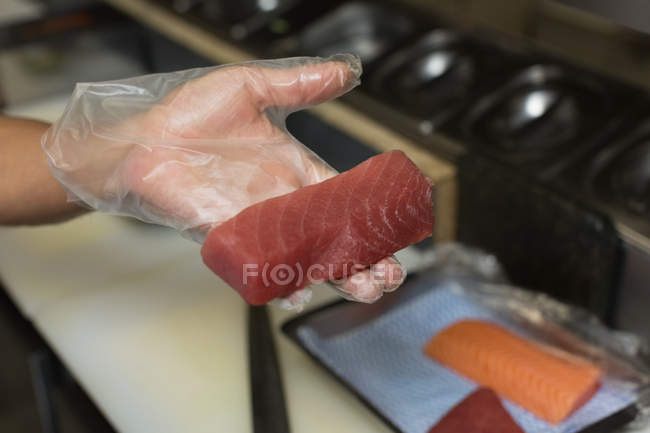 Крупный план шеф-повара, держащего морепродукты на кухне в ресторане — стоковое фото