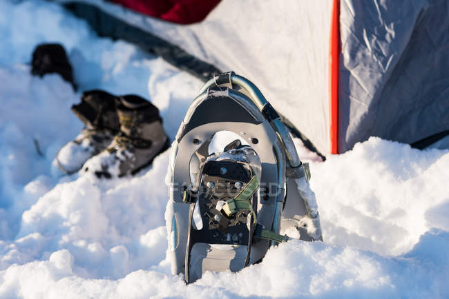 Nahaufnahme von Schneeschuhen und Schuhen in der Nähe des Zeltes im Schnee. — Stockfoto