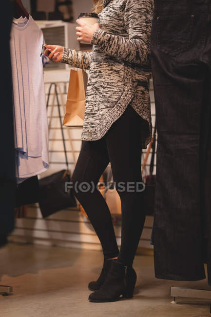 Low section of girl checking price tag while shopping in the mall — Stock Photo