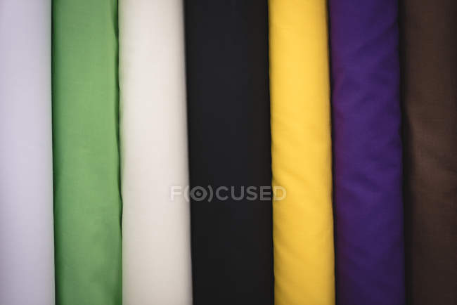 Primo piano vari tessuti di colore disposti in fila in sartoria — Foto stock