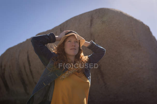 Красива жінка, що стоїть руками на голові на пляжі — стокове фото