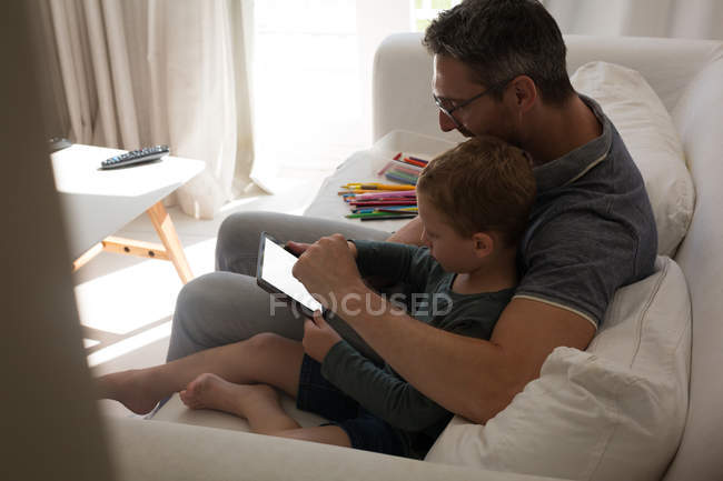 Батько і син використовують цифровий планшет у вітальні вдома — стокове фото