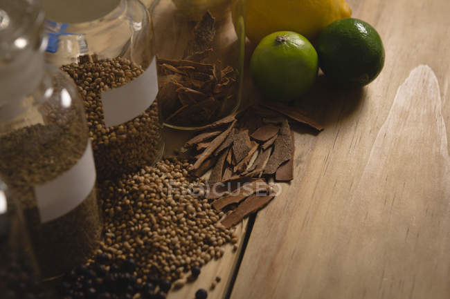 Primer plano de ingredientes de limón y especias en la mesa en la fábrica de ginebra - foto de stock