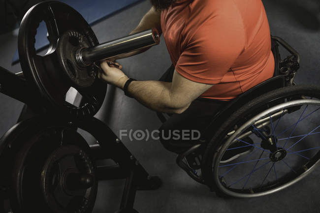 Handicapped man adjusting barbell in gym, close-up — Stock Photo