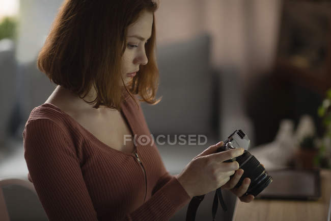 Frau überprüft Merkmale vor der Kamera zu Hause — Stockfoto
