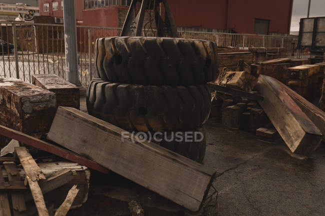 Wooden plank and tyre at scrapyard near shipyard — Stock Photo