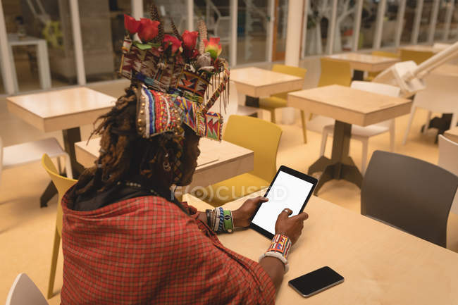 Uomo Maasai in abbigliamento tradizionale utilizzando tablet digitale al centro commerciale — Foto stock