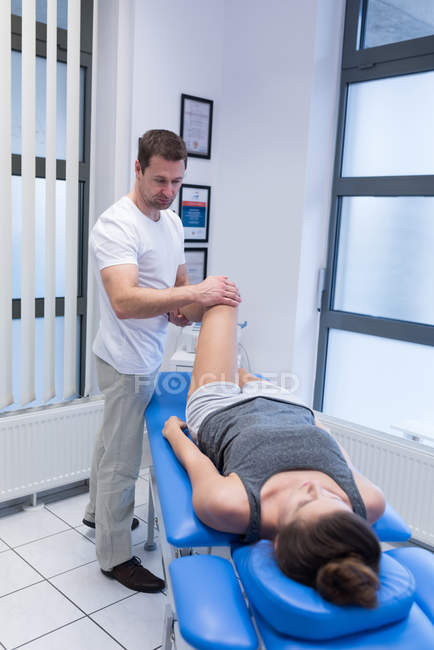 Physiothérapeute donnant massage des jambes à la femme à la clinique — Photo de stock