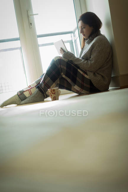 Frau nutzt digitales Tablet im heimischen Wohnzimmer. — Stockfoto