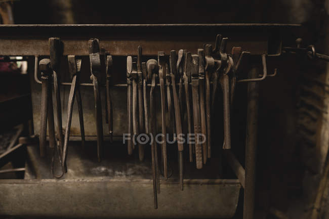 Différentes pinces suspendues dans l'atelier — Photo de stock