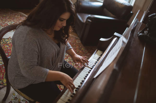 Beautiful female vlogger playing piano at home — Stock Photo
