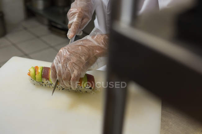 Close-up de chef sênior preparando sushi na cozinha no restaurante — Fotografia de Stock