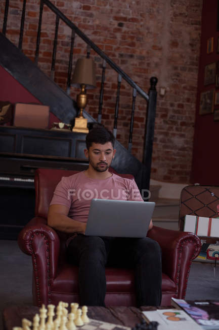 Cliente masculino usando el ordenador portátil en la barbería - foto de stock