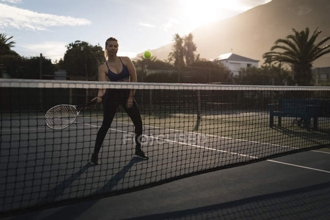 Young woman practicing tennis in tennis court — Stock Photo