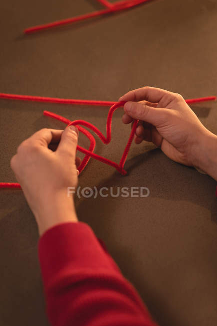 Nahaufnahme eines Jungen bei der Vorbereitung der Dekoration in Herzform zu Hause — Stockfoto