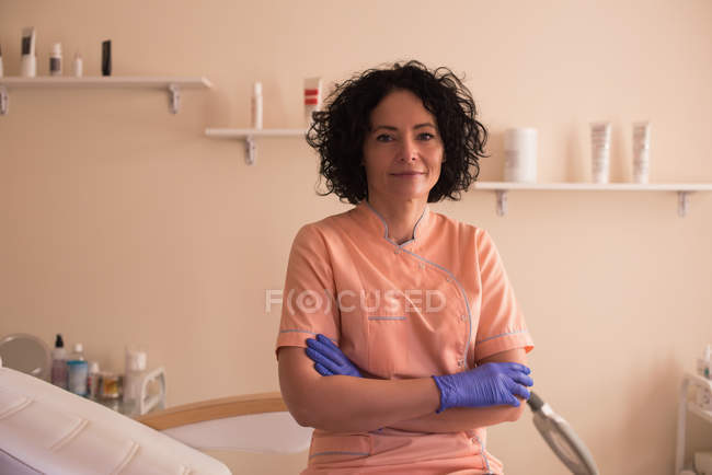 Portrait of female beautician standing with arms crossed in parlour — Stock Photo