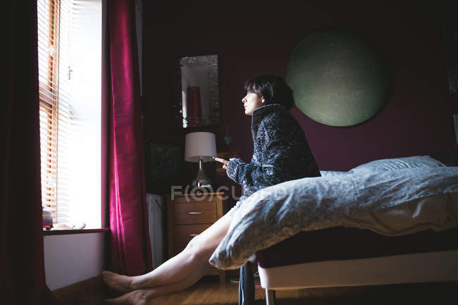 Mulher usando telefone celular no quarto em casa — Fotografia de Stock