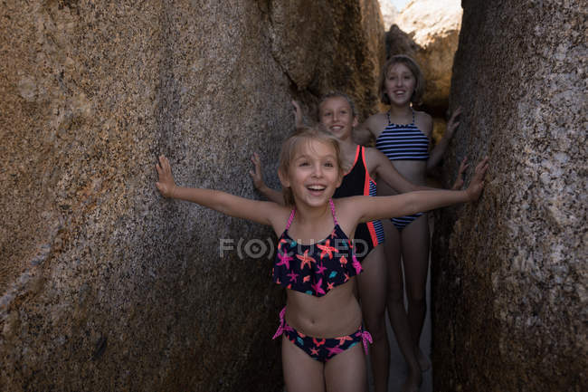 Glückliche Geschwister stehen zwischen Felsen am Strand — Stockfoto