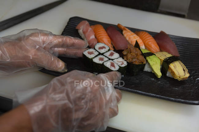 Nahaufnahme des Küchenchefs beim Arrangieren von Sushi in einem Tablett im Restaurant — Stockfoto