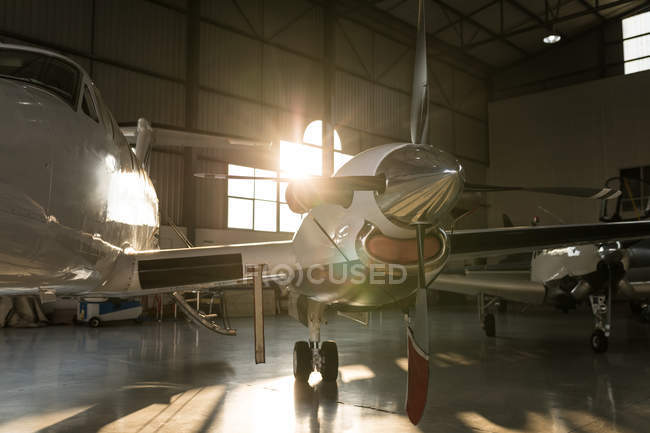 Private jet parked in hangar interior — Stock Photo