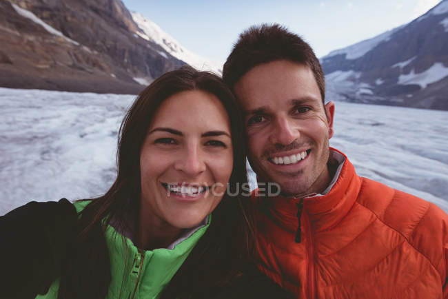 Retrato de pareja feliz sonriendo durante el invierno - foto de stock