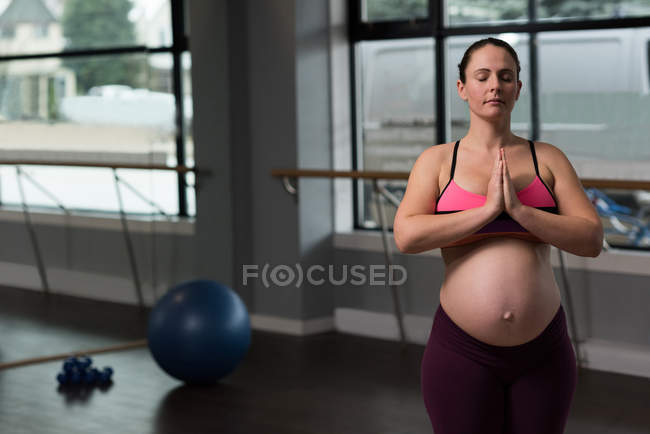 Femme enceinte effectuant du yoga — Photo de stock