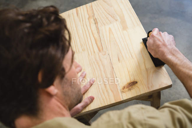 Male carpenter working on wood in workshop — Stock Photo