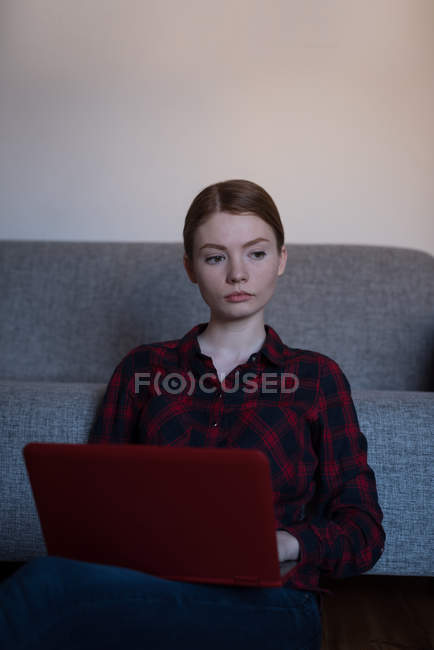 Junge Frau mit Laptop im heimischen Wohnzimmer — Stockfoto