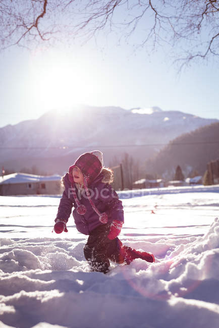 Carefree girl walking in snow during winter — Stock Photo