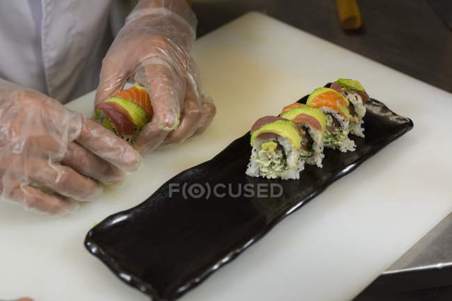 Senior chef preparing sushi in kitchen at hotel — Stock Photo