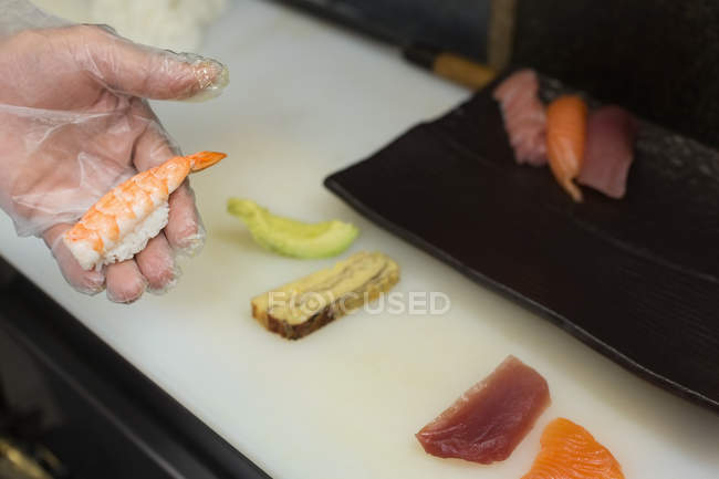 Chef sosteniendo comida de mar en la cocina del hotel - foto de stock