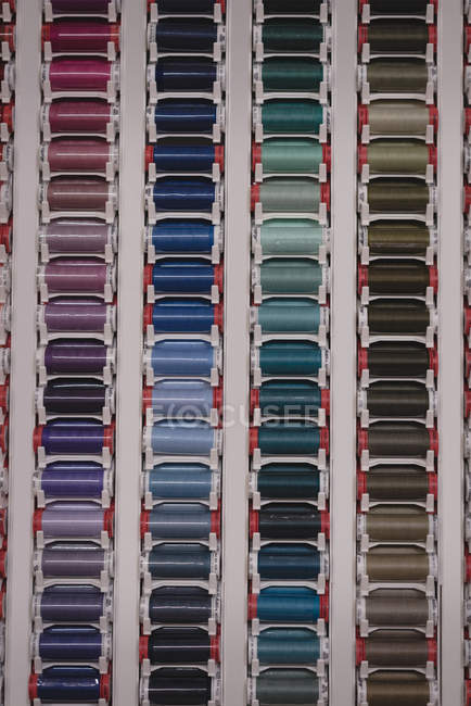 Fios multicoloridos dispostos em linha na loja de alfaiate — Fotografia de Stock