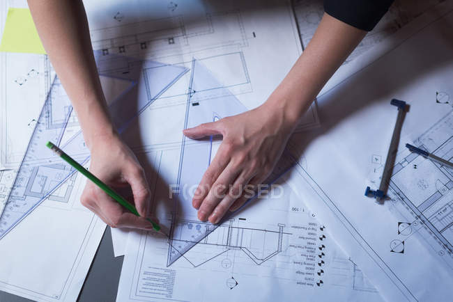 Close-up of female executive working on blueprint in office — Stock Photo