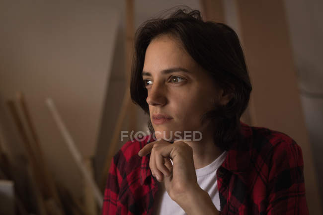 Thoughtful craftswoman relaxing in workshop, portrait. — Stock Photo