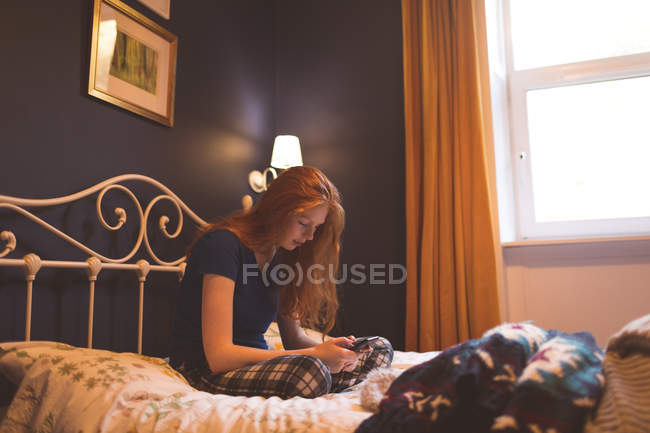 Жінка використовує мобільний телефон в спальні вдома — стокове фото