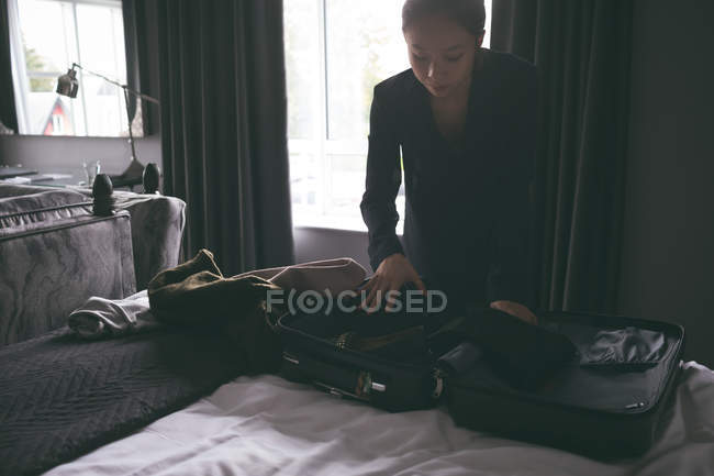 Woman packing her bag in hotel — Stock Photo