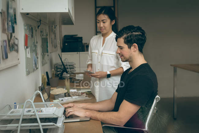 Executives discussing over laptop in office — Stock Photo