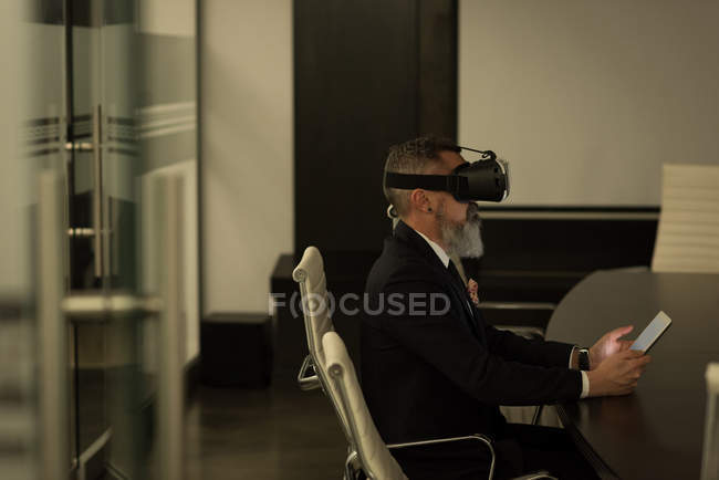 Керівник бізнесу, використовуючи гарнітуру віртуальної реальності в офісі — стокове фото