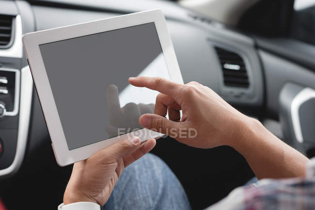Крупный план мужских рук с помощью цифрового планшета в автомобиле — стоковое фото