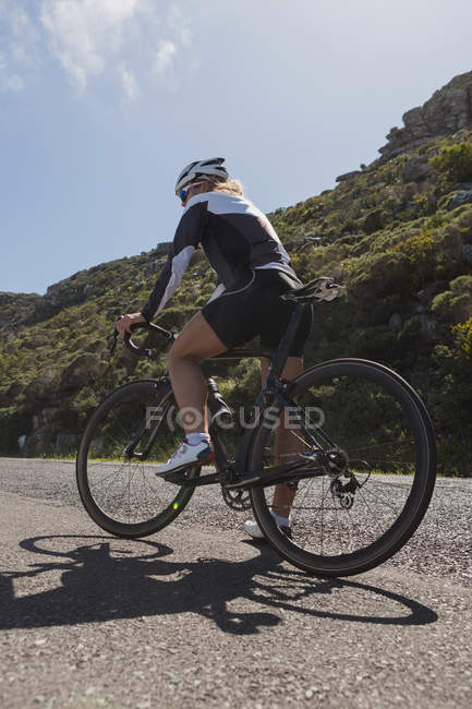 Жінка-велосипедистка відпочиває по дорозі в сонячний день — стокове фото