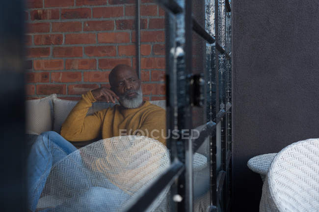 Nachdenklicher Senior entspannt sich zu Hause auf Sofa — Stockfoto