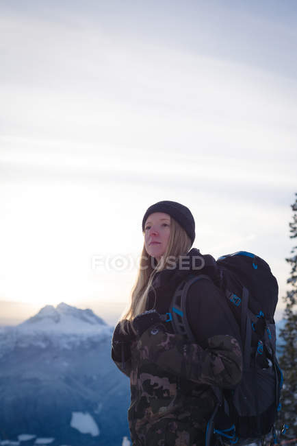 Thoughtful woman standing on snow covered landscape during winter — Stock Photo