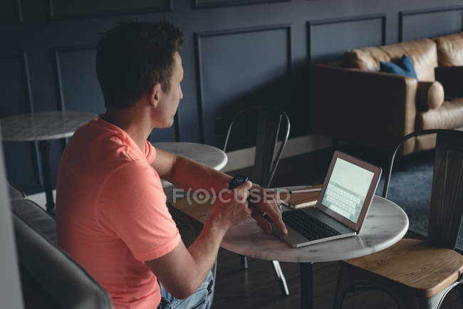 Uomo d'affari che utilizza smartwatch in mensa in ufficio — Foto stock